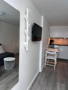 ein kleines Wohnzimmer mit einer Küche und einem Tisch in der Unterkunft Lägenhet med egen ingång. in Sundsvall