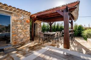 un patio con tavolo e sedie e un muro di pietra di Casa da Alvorada a Tavira