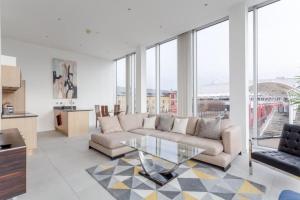 a living room with a couch and a glass table at Luxury 1Bed In Converted Warehouse Next To London Excel in London