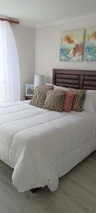 une chambre avec deux lits avec des oreillers dessus dans l'établissement Departamento para 6 personas, à Iquique