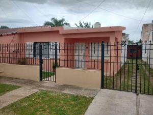 un bâtiment rose avec une clôture devant lui dans l'établissement Casa Interna Paraná, à Paraná