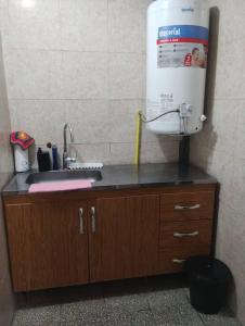 un comptoir de cuisine avec évier et un chauffe-eau dans l'établissement Casa Interna Paraná, à Paraná