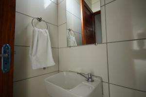 a bathroom with a sink and a mirror and a towel at Pousada Girassol in Maceió