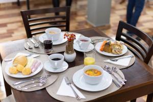 a wooden table with plates of breakfast food on it at Metro Hotel in Águas de Lindoia