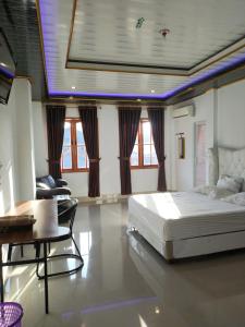 a bedroom with a bed and a table and chairs at Penginapan Nurmega jaya 
