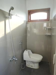 a small bathroom with a toilet and a window at Penginapan Nurmega jaya 