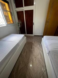 - une chambre avec 2 lits et une fenêtre avec un ventilateur dans l'établissement Nouvel appartement idéal, à Guercif