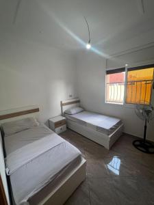 - une chambre avec 2 lits et une fenêtre dans l'établissement Nouvel appartement idéal, à Guercif