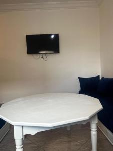 uma mesa branca com uma televisão na parede em Nouvel appartement idéal em Guercif