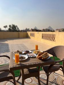 een tafel met eten en drinken op een patio bij four pyramids Guest house in Caïro