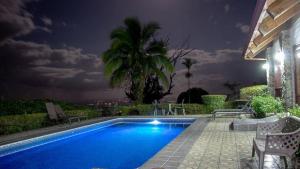 a swimming pool in a yard at night at Villas y Cataratas Maquengue Falls in Siquirres