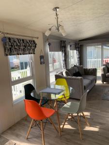 een woonkamer met kleurrijke stoelen en een tafel bij Aurora luxury beach lodge in Lossiemouth