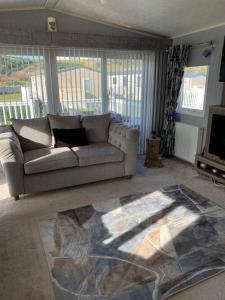 a living room with a couch and a rug at Aurora luxury beach lodge in Lossiemouth