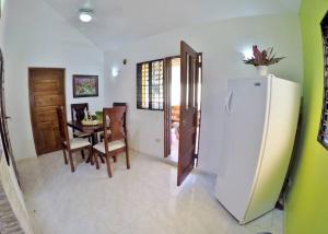 eine Küche und ein Esszimmer mit einem Kühlschrank und einem Tisch in der Unterkunft Coco Banana Resort Appartment 1 in Las Galeras