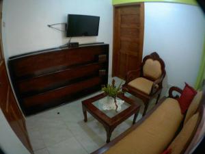 sala de estar con sofá, mesa y TV en Coco Banana Resort Appartment 1 en Las Galeras