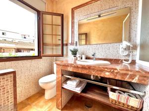 a bathroom with a sink and a toilet and a mirror at Calma Suite in Agulo