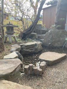 un jardin avec des rochers, une pagode et un étang dans l'établissement Ichie, à Tanabe