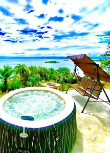 bañera de hidromasaje con silla y sombrilla en MISTY MOONLIGHT VILLAS en Bocas del Toro