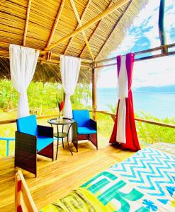 Pokój z łóżkiem i krzesłami oraz widokiem na ocean w obiekcie MISTY MOONLIGHT VILLAS w mieście Bocas del Toro