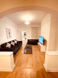 a living room with a couch and a table at 5 STAR BIG SPACIOUS 2 BEDROOM HOUSE, SLEEPS 8, FREE STREET PARKING, EASY ACCESS LOCK BOX ENTRY, 2 minute drive from city centre in Liverpool