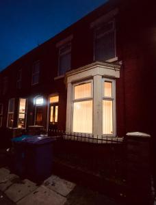 una casa con luces en la ventana por la noche en 5 STAR BIG SPACIOUS 2 BEDROOM HOUSE, SLEEPS 8, FREE STREET PARKING, EASY ACCESS LOCK BOX ENTRY, 2 minute drive from city centre, en Liverpool