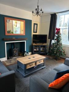 a living room with a christmas tree and a coffee table at The Buxton Retreat A Luxurious 3-Storey Townhouse with Four Poster Bed and Double Jacuzzi Bath" in Buxton