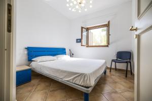 una camera con un letto blu e una sedia blu di La Casetta del Porticciolo a Pisticci