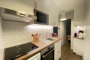 cocina blanca con fregadero y microondas en Ski in and ski out apartment Superdévoluy, en Le Dévoluy