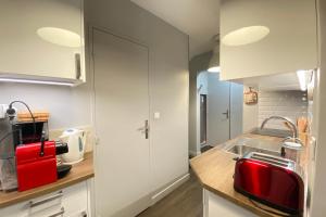 una cocina con fregadero y un aparato rojo en Ski in and ski out apartment Superdévoluy, en Le Dévoluy