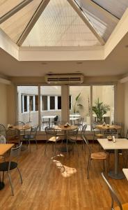 una sala da pranzo con tavoli, sedie e finestre di Intersur Suites a Buenos Aires