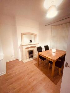 a dining room with a table and a fireplace at BIG SPACIOUS 2 BEDROOM HOUSE, SLEEPS 8, FREE STREET PARKING, EASY ACCESS LOCK BoX ENTRY, NO PARTIES! in Liverpool