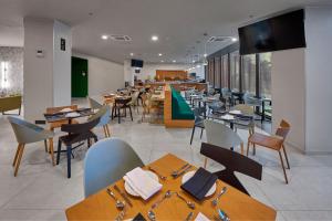 a dining room with tables and chairs in a restaurant at City Express Plus by Marriott Merida in Mérida