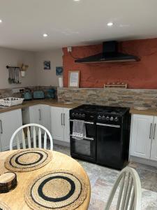 a kitchen with a table and a black stove at The Buxton Retreat A Luxurious 3-Storey Townhouse with Four Poster Bed and Double Jacuzzi Bath" in Buxton