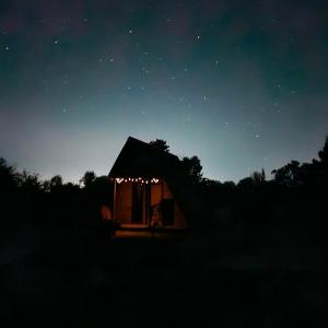 una pequeña cabaña de noche con luces encendidas en Cabaña de huéspedes en un microviñedo familiar, en Rauco