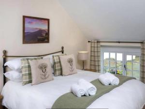 Un pat sau paturi într-o cameră la Coachingmans Cottage