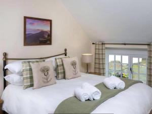 a bedroom with a bed with towels on it at Coachingmans Cottage in Trecastle