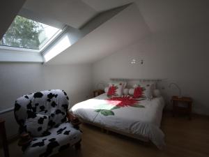 een slaapkamer met een zwart-wit bed en een stoel bij Gîte Granges-Aumontzey-Granges-sur-Vologne, 3 pièces, 5 personnes - FR-1-589-122 in Granges-sur-Vologne