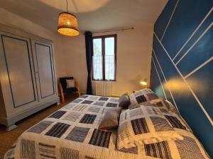 een slaapkamer met een bed met een blauwe muur bij Gîte La Berthenoux, 3 pièces, 5 personnes - FR-1-591-428 in La Berthenoux