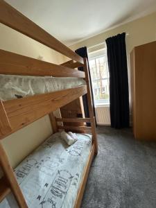 1 dormitorio con 2 literas y ventana en The Buxton Retreat A Luxurious 3-Storey Townhouse with Four Poster Bed and Double Jacuzzi Bath", en Buxton