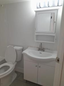 Baño blanco con aseo y lavamanos en Furnished rooms close to U of A in Edmonton, en Edmonton