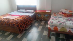 a bedroom with two twin beds and a dresser at DENZONG HOMESTAY Lhadinkyu in Temi