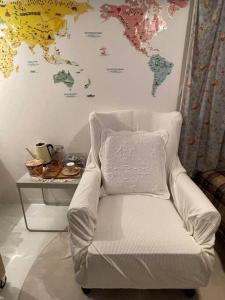 a white chair in a room with a map on the wall at 経堂の小さなお部屋cottu in Tokyo