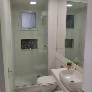 y baño con ducha, aseo y lavamanos. en Apartamento Temporada Mobiliado Proximo a Praia, en Vila Velha
