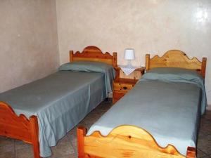 a bedroom with two beds and a table and a lamp at Bed & Breakfast La Corte in Zanica