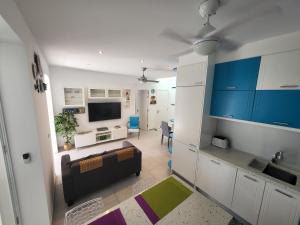 a kitchen and living room with a couch and a tv at Apartamento Makai in Puerto de Mogán