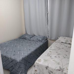 - une petite chambre avec un lit et un rideau dans l'établissement Apartamento Temporada Mobiliado Proximo a Praia, à Vila Velha