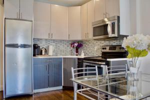 a kitchen with a stainless steel refrigerator and a glass table at 10 Minutes from NYC - Astoria LIC CityView in Steinway