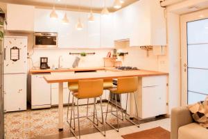 uma cozinha com armários brancos e uma mesa e cadeiras em Cosy 38 m love nest near Centquatre-Paris em Paris