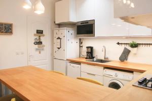 uma cozinha com um frigorífico branco e um lavatório em Cosy 38 m love nest near Centquatre-Paris em Paris