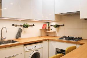 uma cozinha com armários brancos e uma máquina de lavar louça em Cosy 38 m love nest near Centquatre-Paris em Paris